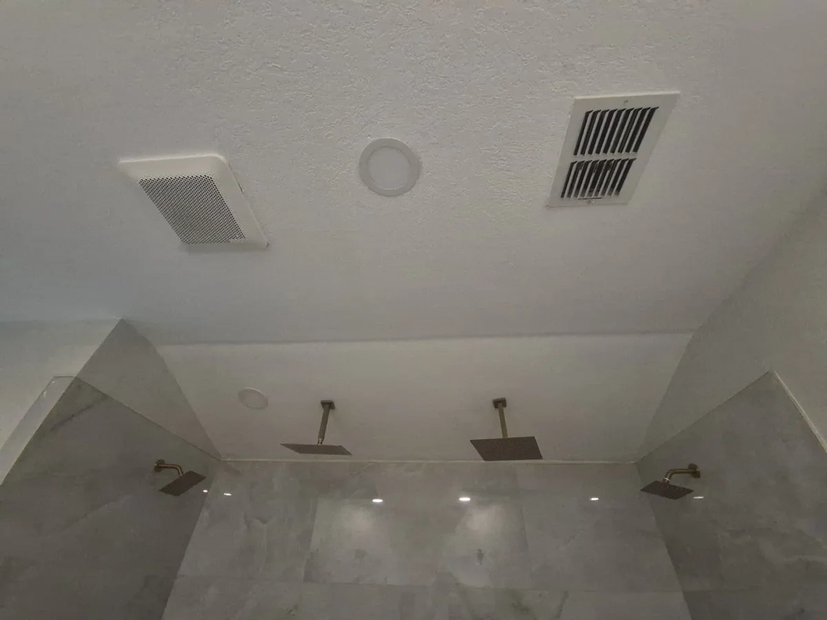 Finished bathroom with painted ceiling and tiled shower